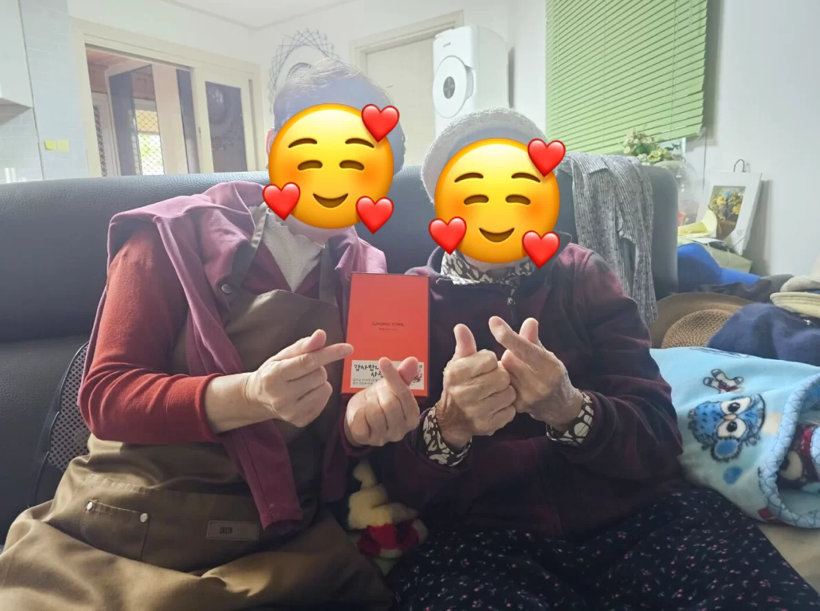 어르신 두 분이 감사 카드 들고 환하게 웃는 모습