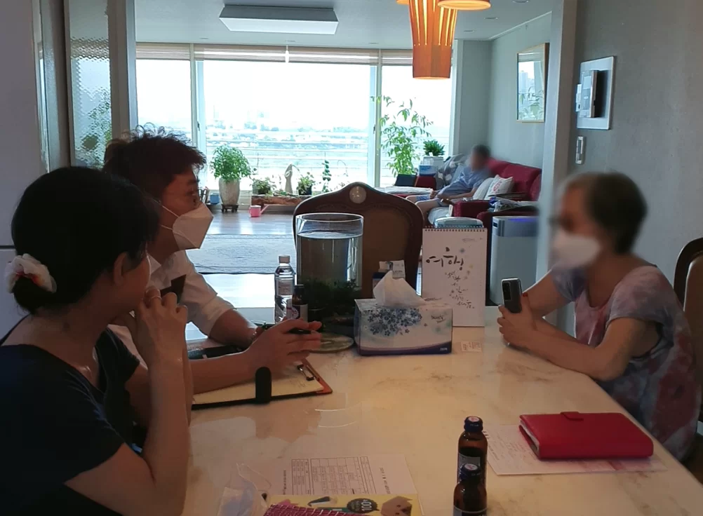 조사원이 어르신과 가족을 마주보고 인지 상태를 확인하는 인터뷰 장면