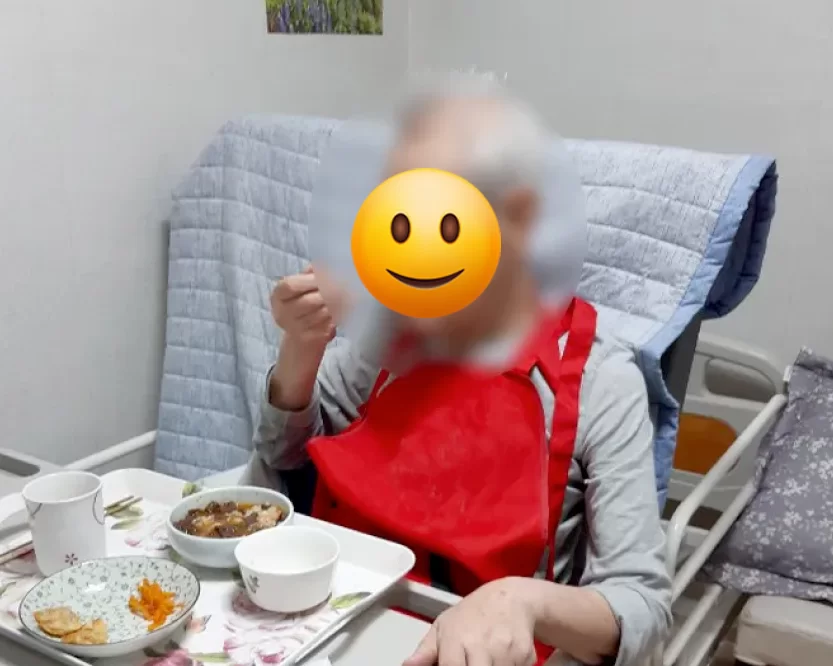 침대에서 식사하는 거동 불편한 어르신 모습을 통해 노인장기요양보험 제도의 필요성을 보여주는 케어링 가이드 도입 이미지