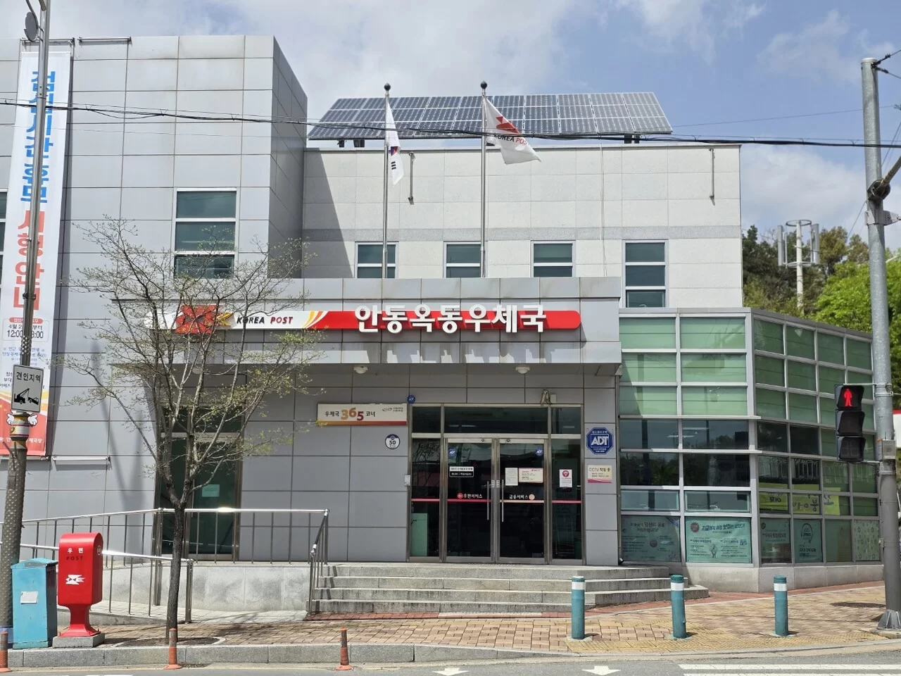 동네 우체국 외관에 방문해 장기요양등급 신청서를 발송하는 절차를 안내하는 케어링 우편 신청 가이드 이미지
