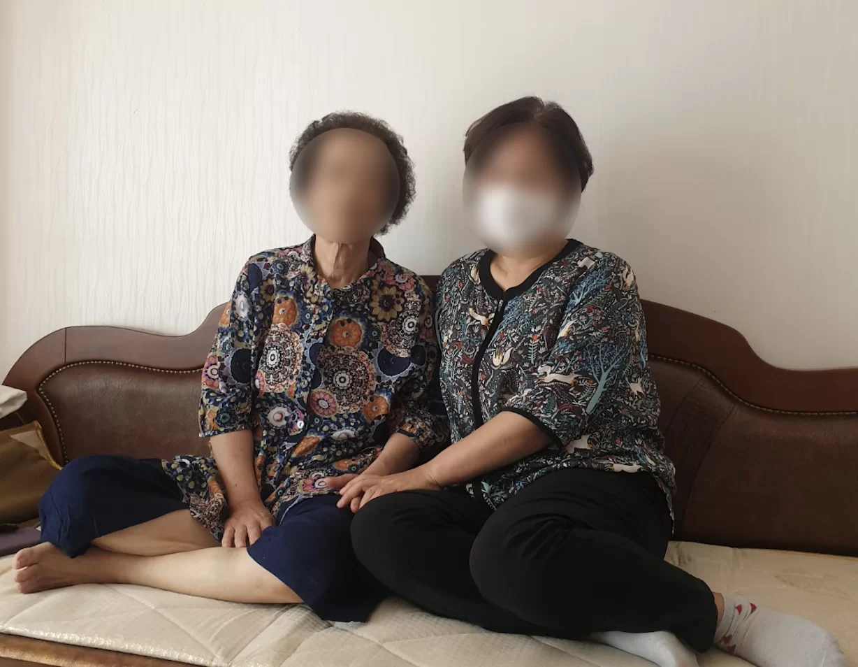 거실에서 어르신과 보호자가 나란히 앉아 있는 모습 — 만 65세 이상 장기요양등급 신청 대상자 상황을 보여주는 케어링 이미지