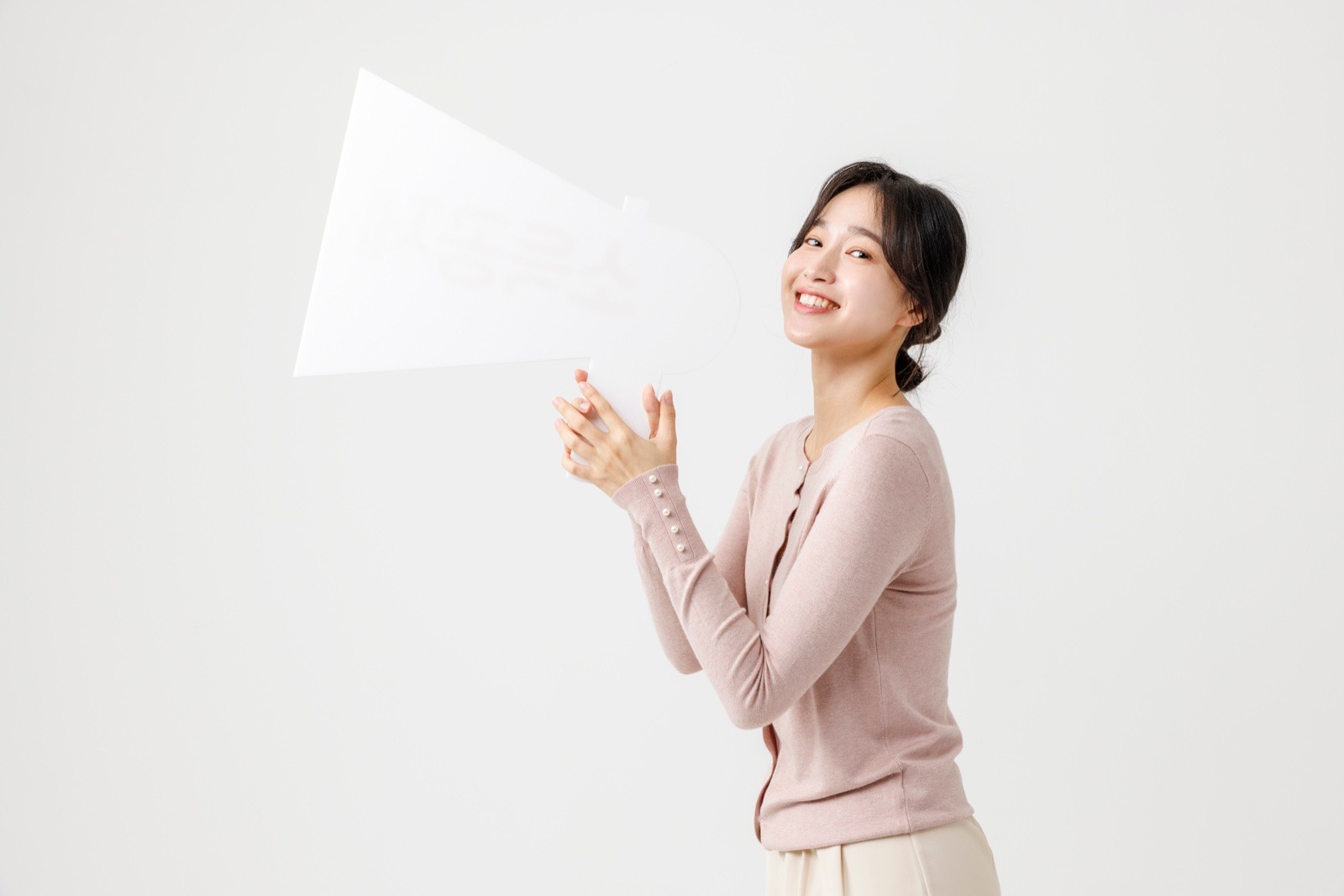 흰색 메가폰 들고 웃는 분홍 카디건 여성