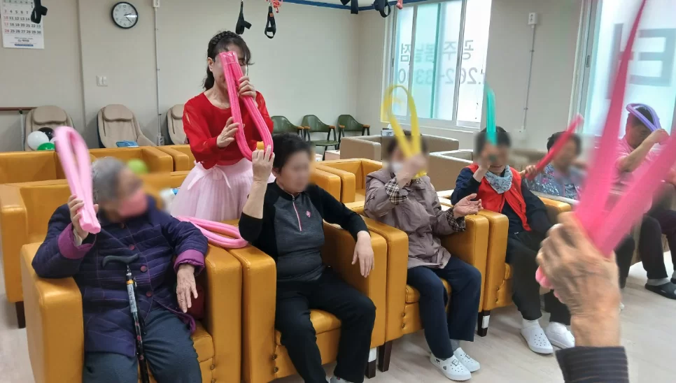 주간보호센터에서 풍선 들고 활동하는 어르신들