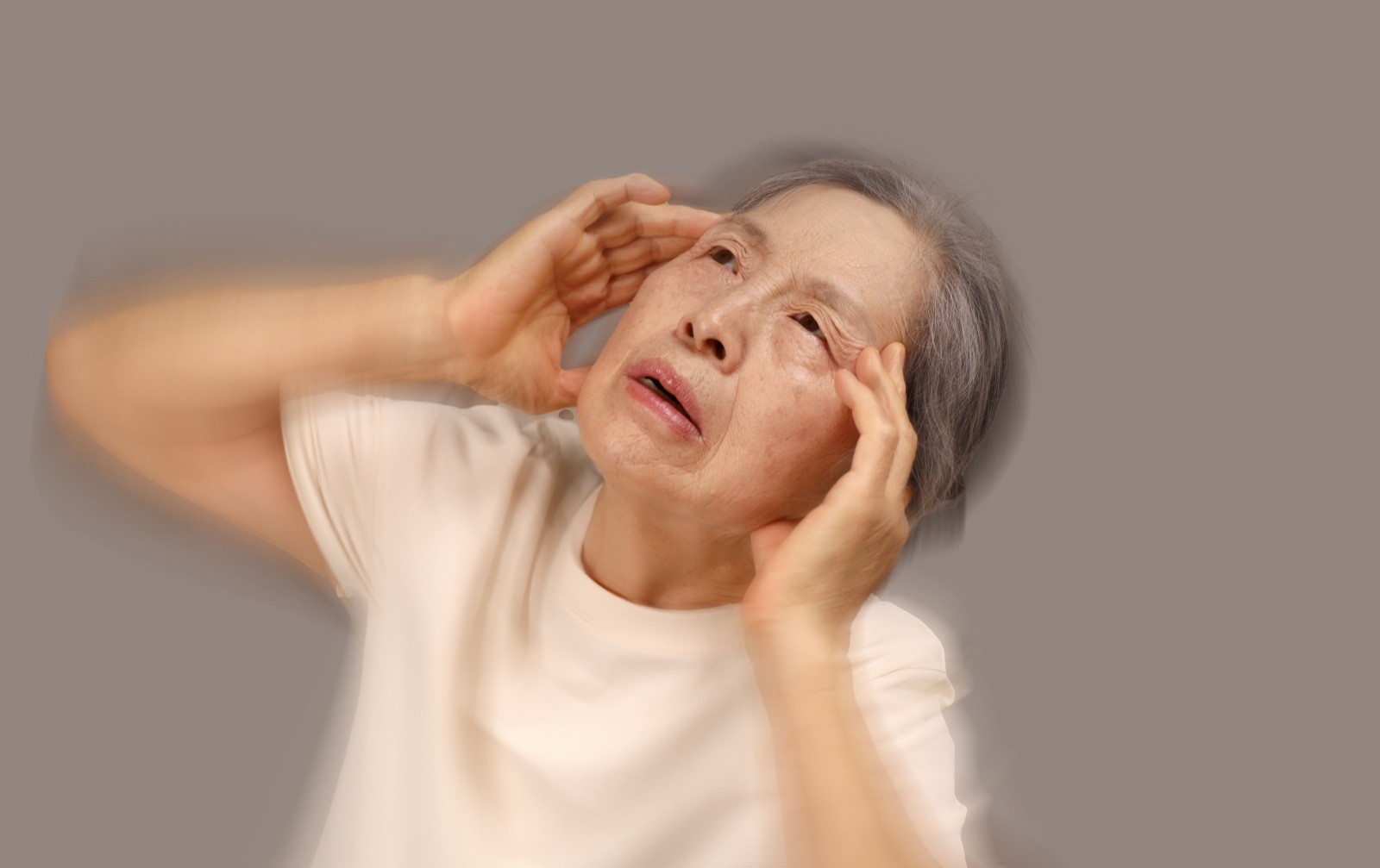 양손으로 머리 짚고 어지러워하는 어르신