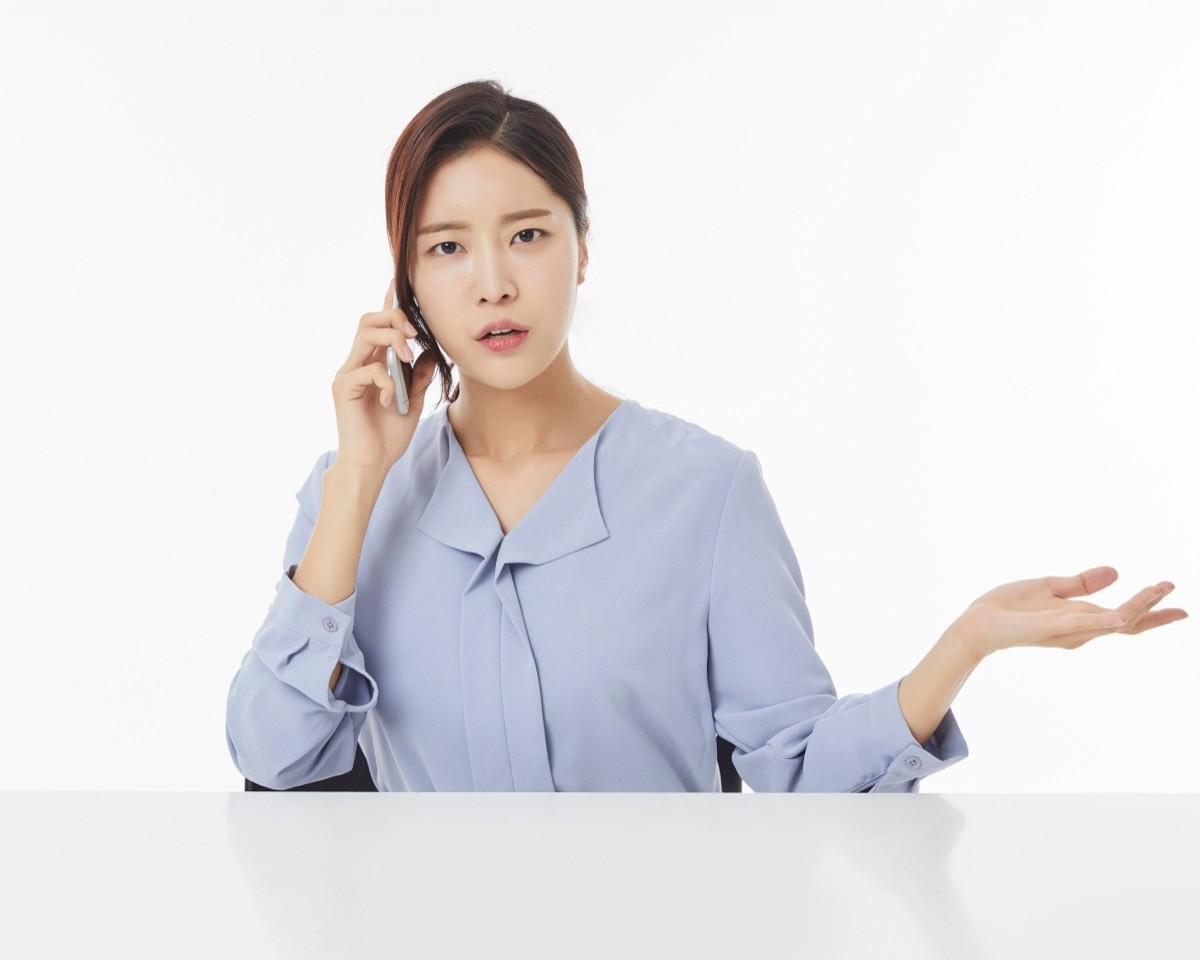 전화 통화하며 손바닥 펴고 의아해하는 여성
