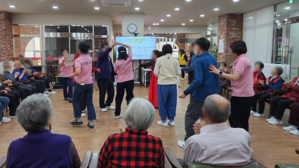 어르신들이 둘러서서 함께 체조하는 모습