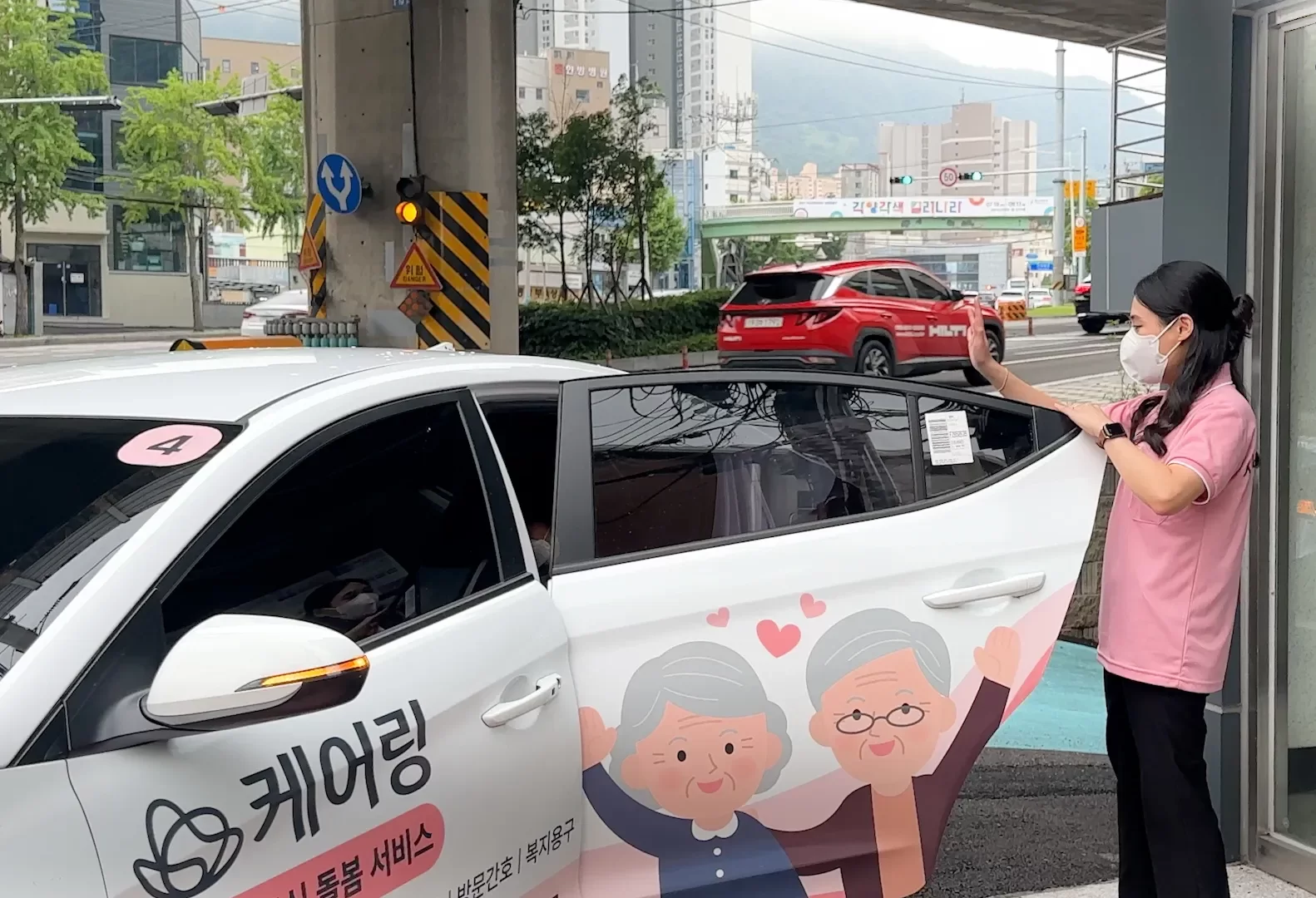 직원이 하원 차량 앞에서 어르신을 배웅하는 모습