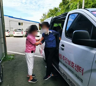 보조원이 어르신의 차량 승하차를 돕는 모습