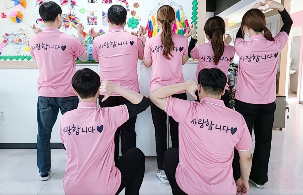 사랑합니다 적힌 분홍 티셔츠를 입은 센터 직원들