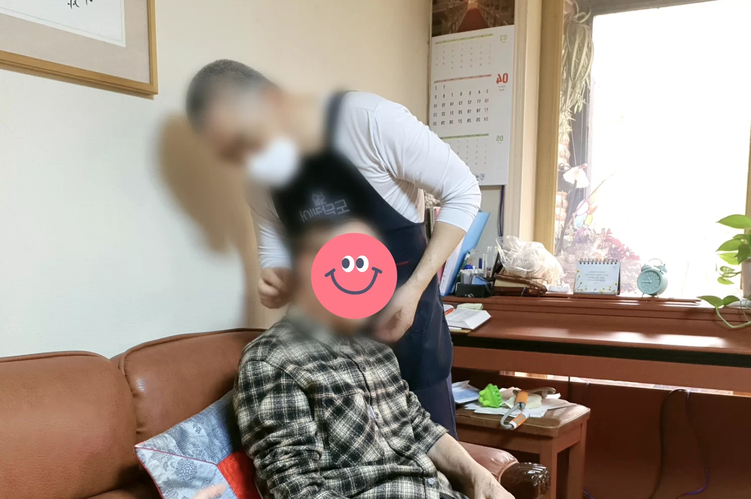 요양보호사가 어르신을 소파에서 부축하는 모습