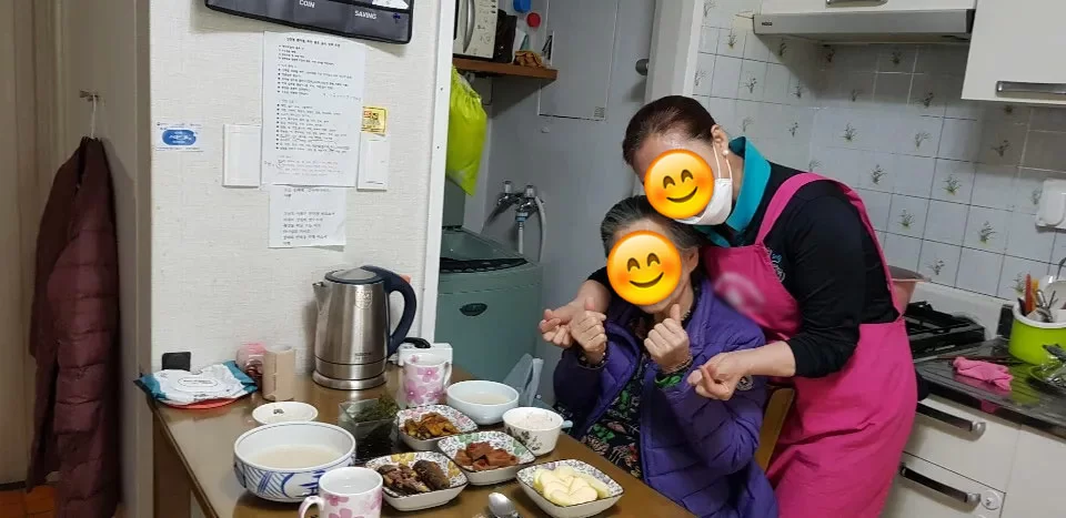 부엌에서 요양보호사가 어르신 식사를 돕는 모습