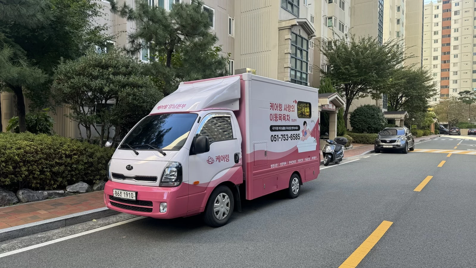 도로변에 주차된 분홍색 이동목욕차량 외관