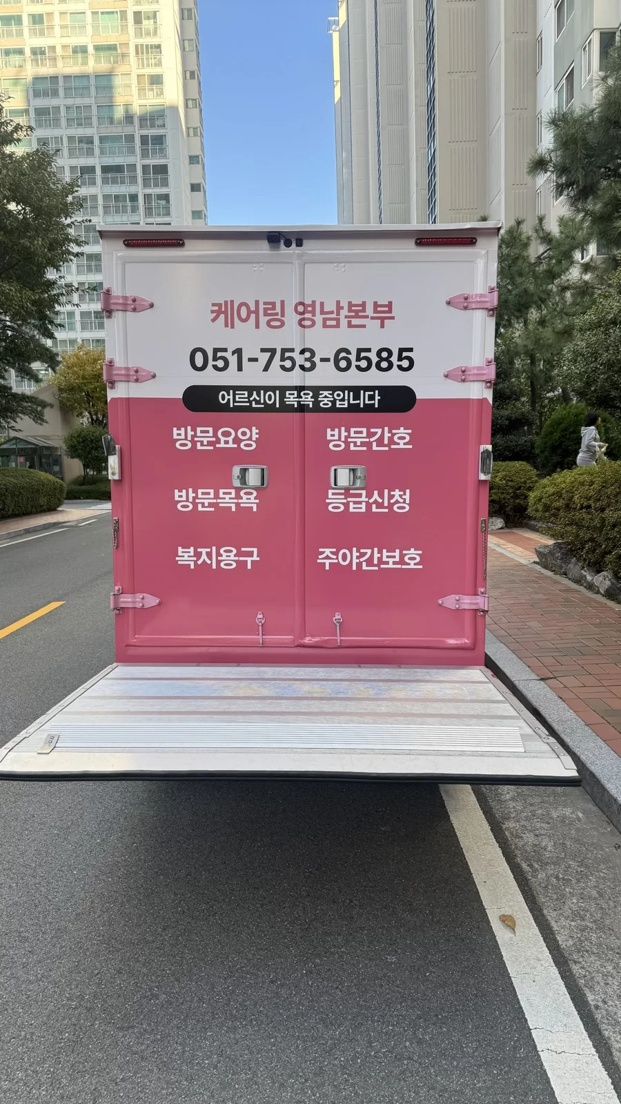 리프트를 바닥까지 펼친 이동목욕차량 후면