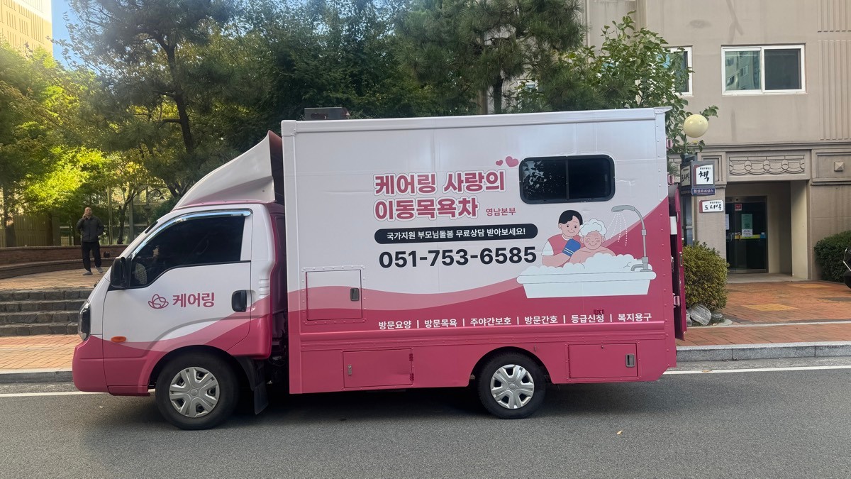 도로변에 주차된 분홍색 이동목욕차량 측면