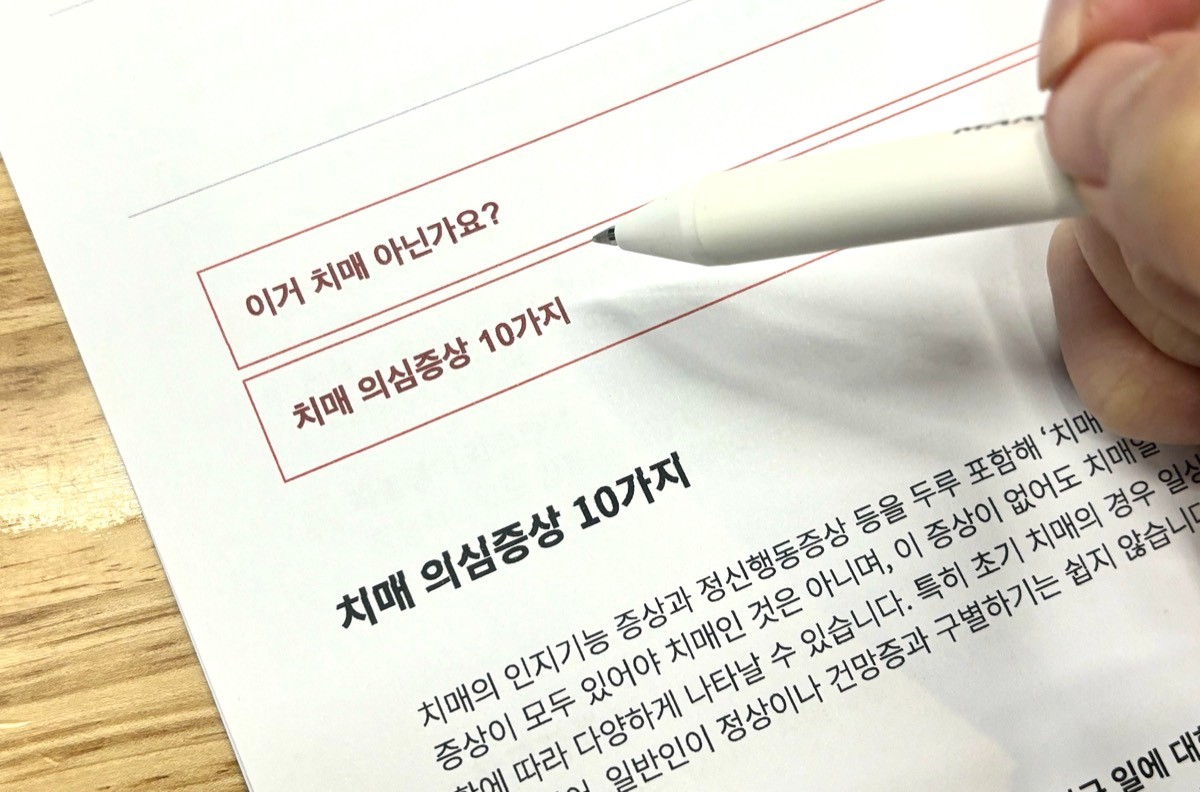 치매 의심증상 체크리스트에 펜으로 표시하는 모습