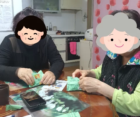 어르신과 요양보호사가 식탁에서 인지 활동하는 모습