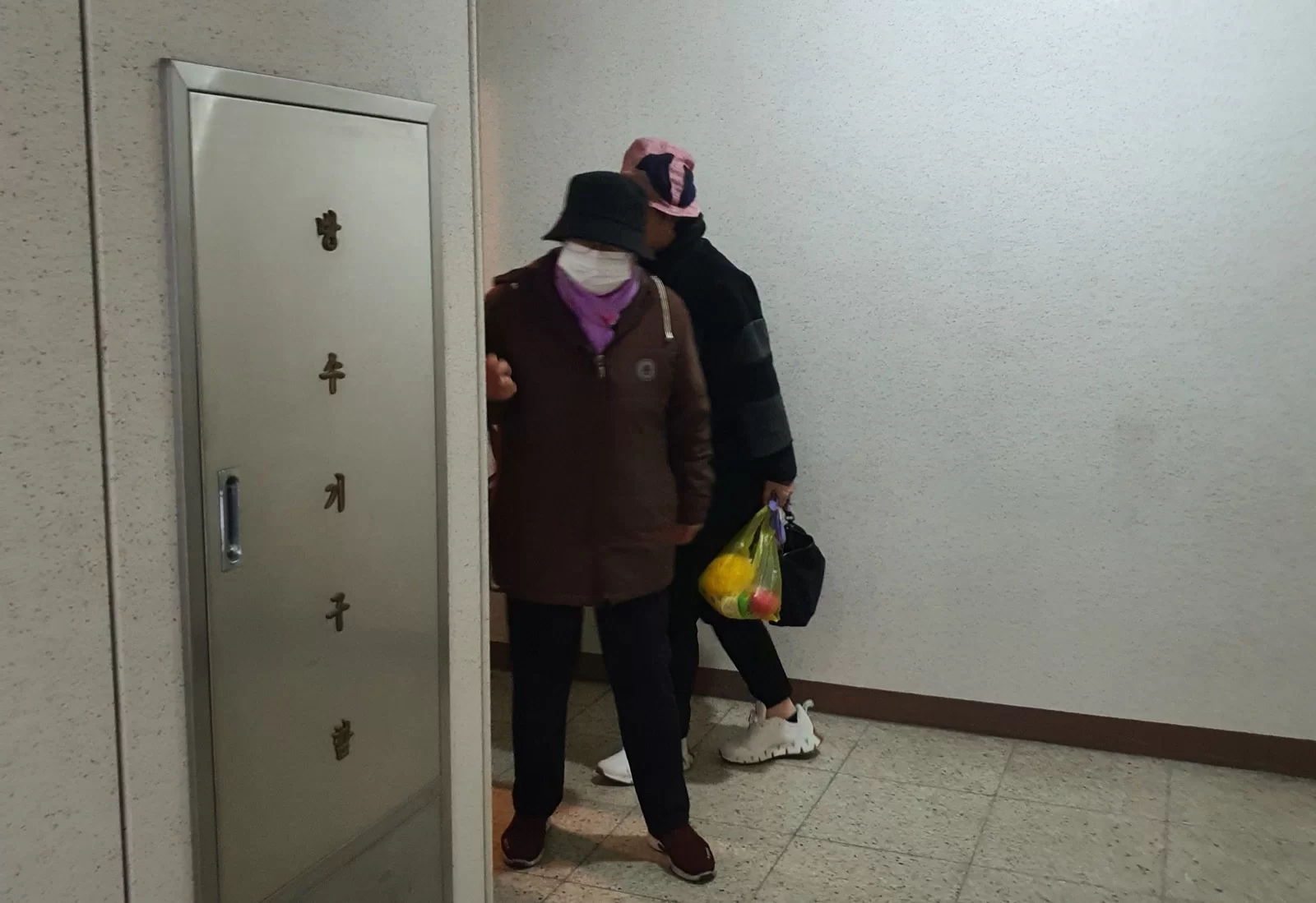 장 본 봉지를 들고 어르신과 현관 앞에 선 모습