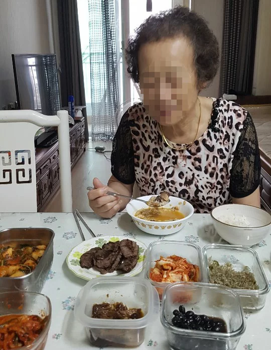 어르신이 여러 반찬이 차려진 밥상 앞에 앉은 모습
