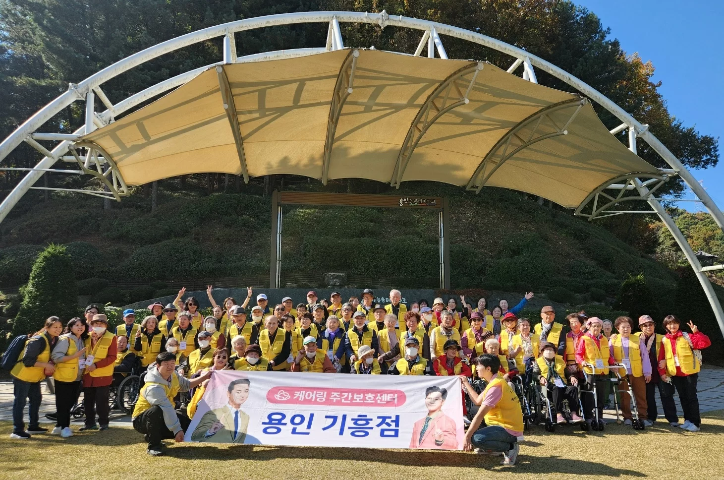 주간보호센터 어르신들이 야외 나들이 단체사진을 찍은 모습