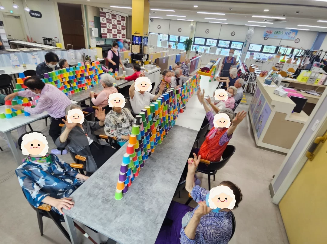 어르신들이 색색 종이컵을 쌓는 활동을 하는 모습