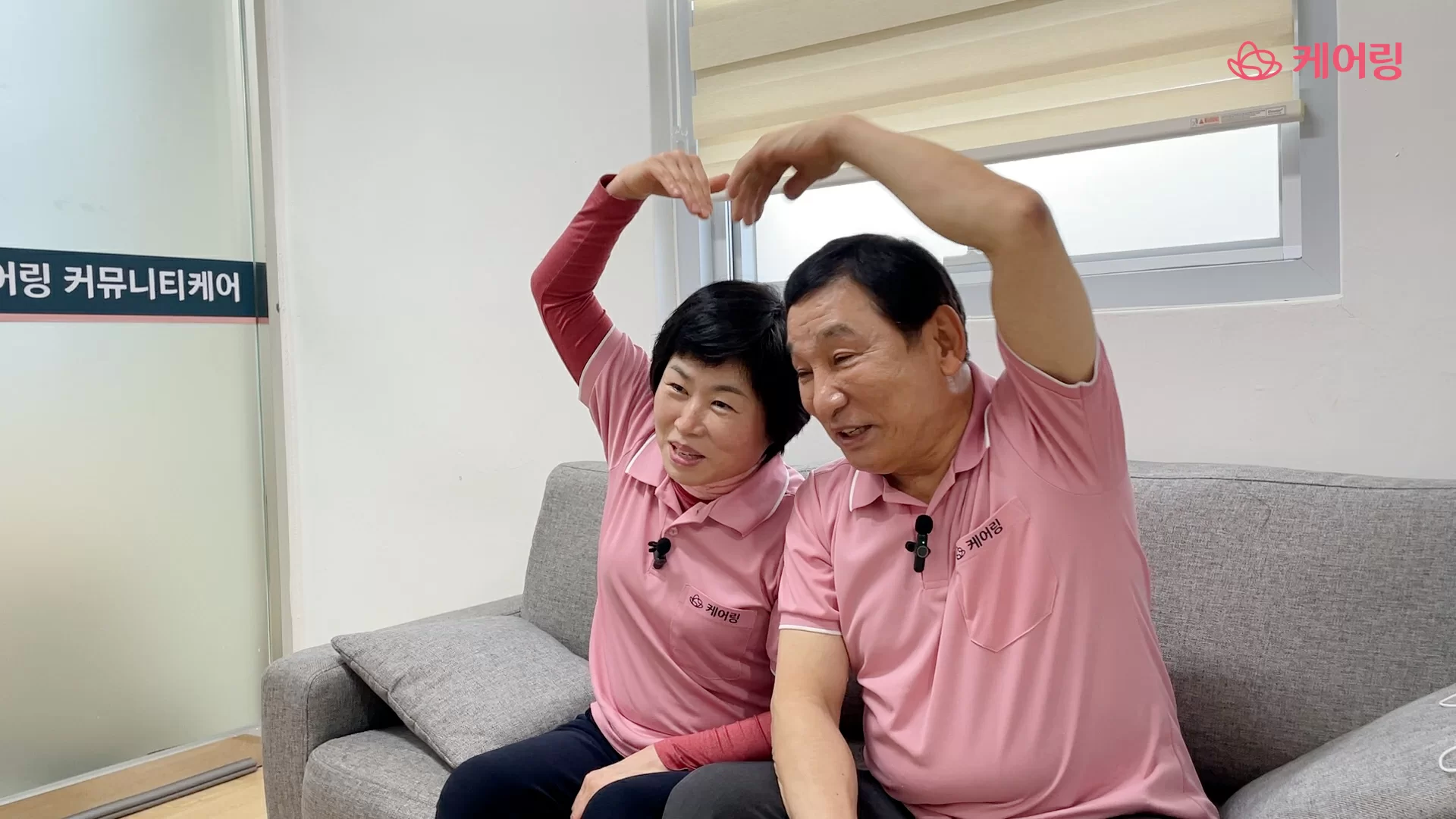 사회복지사와 요양보호사가 머리 위로 하트를 만든 모습