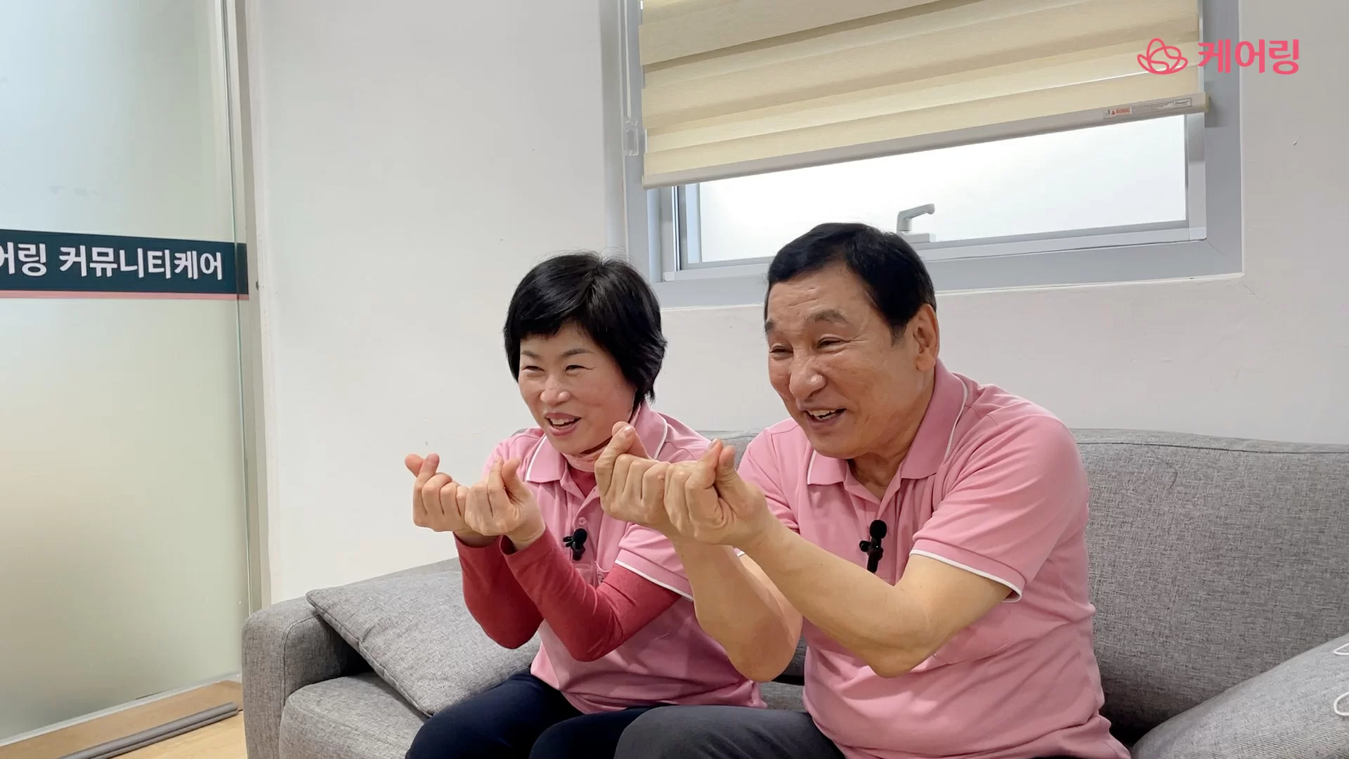 사회복지사와 요양보호사가 손가락 하트를 보이는 모습