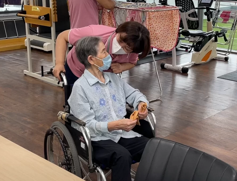 요양보호사가 휠체어 어르신을 살피는 모습