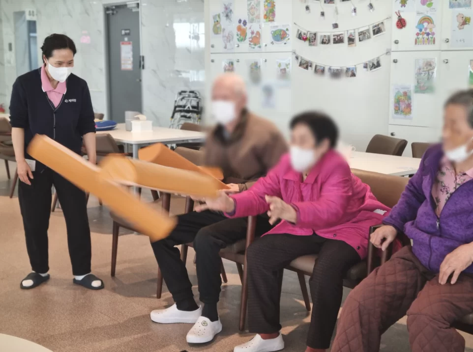 주간보호센터에서 어르신들이 막대 체조하는 모습