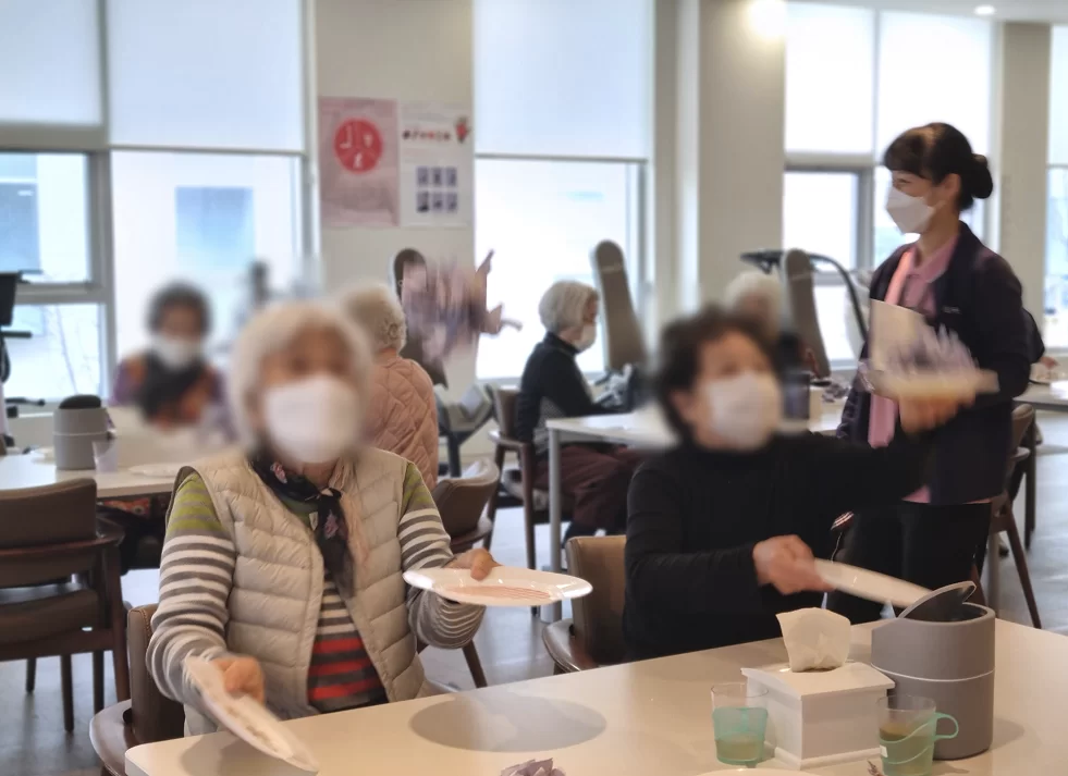 주간보호센터에서 어르신들이 식탁에 둘러앉아 활동
