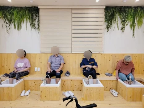 주간보호센터에서 어르신들이 편백나무 족욕을 즐기는 모습