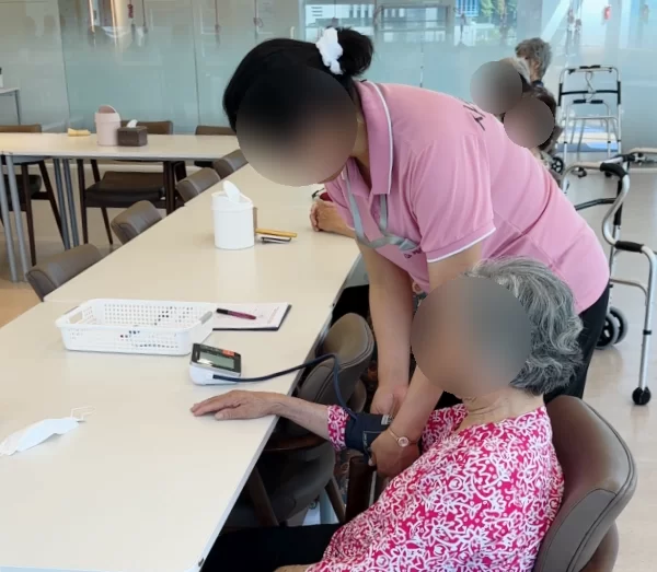주간보호센터 직원이 어르신 건강 상태를 살피는 모습