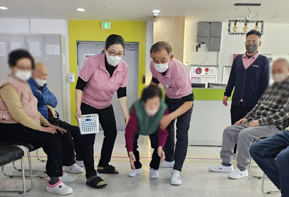 주간보호센터에서 어르신들이 직원과 체조하는 모습