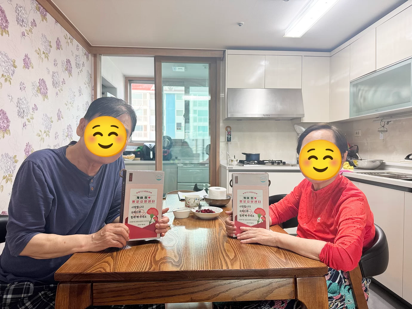어르신 두 분이 케어링 안내 책자를 든 모습